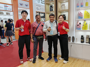 Four people posing in a showroom with products