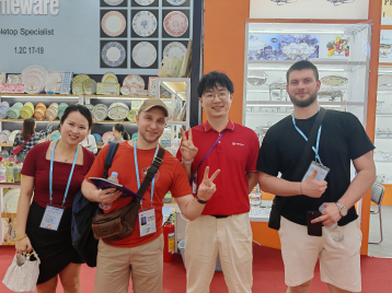 Four people posing in front of tableware display