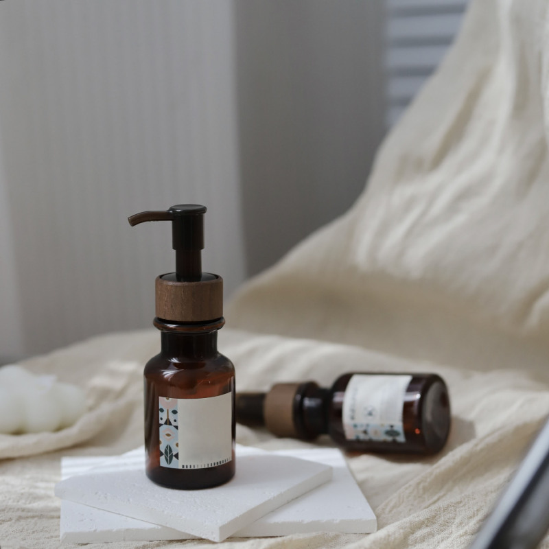 High-End 80ml Amber Plastic Essential Oil Bottle with Lotion Pump Serum Bottle Sample with Wood Grain Cap