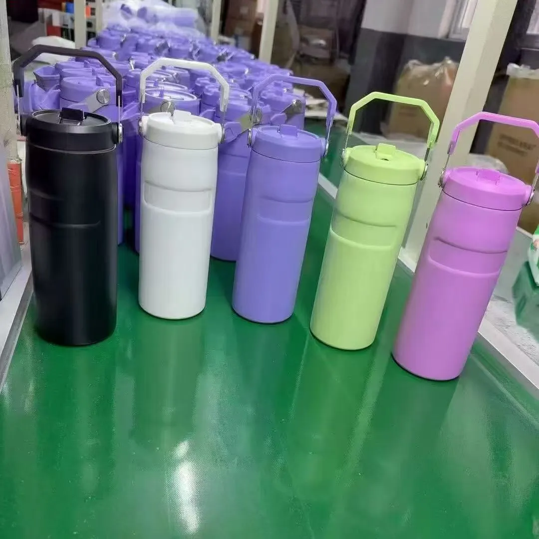 Handled insulated bottles staged on a drinkware factory line before packing
