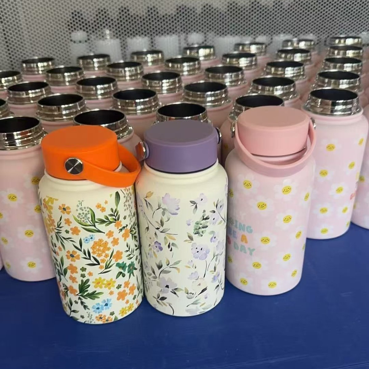 Finished tumbler samples with different colors, printed designs, and handle configurations