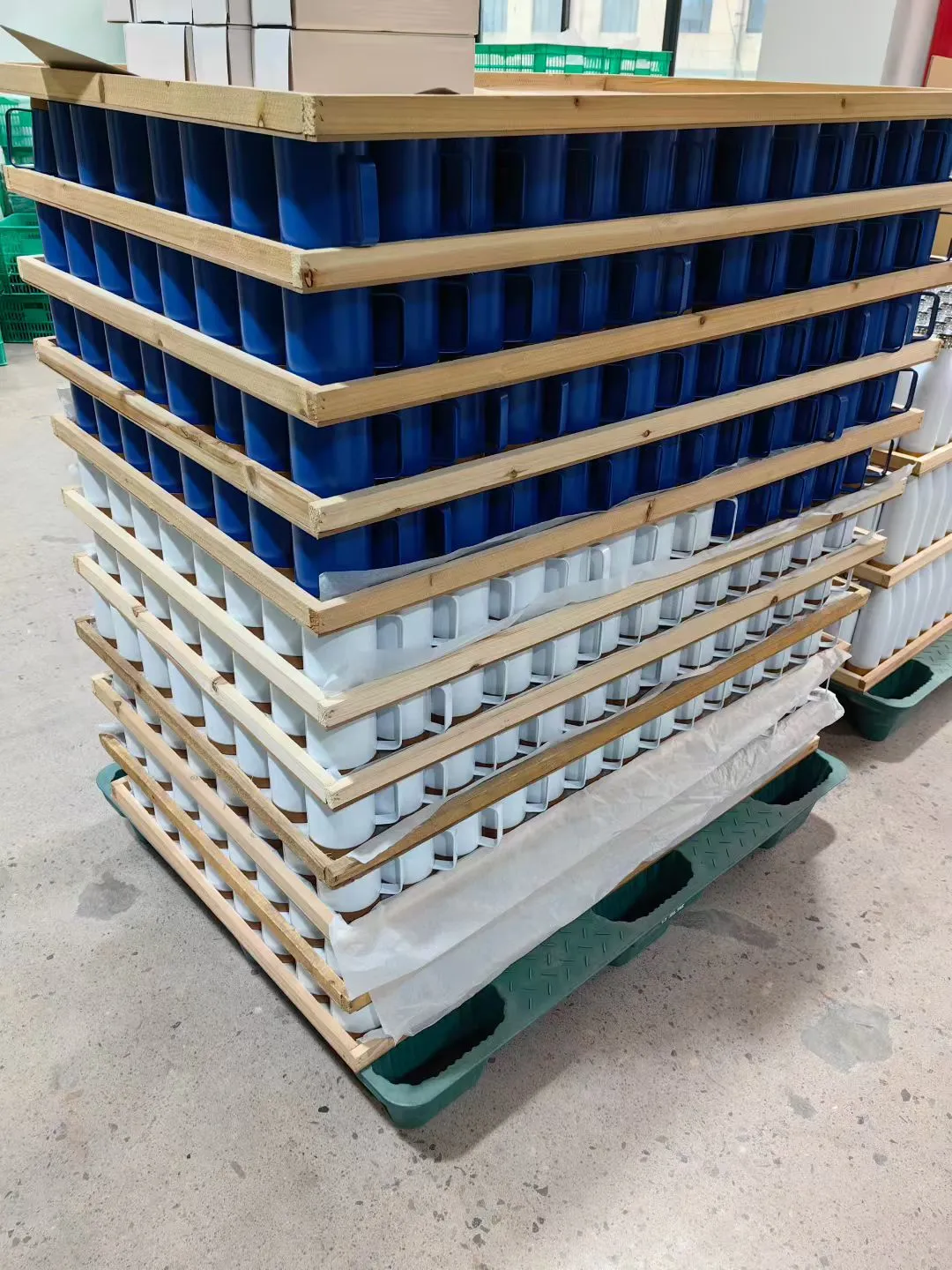 Packaged drinkware stacked on pallets with protective corner supports