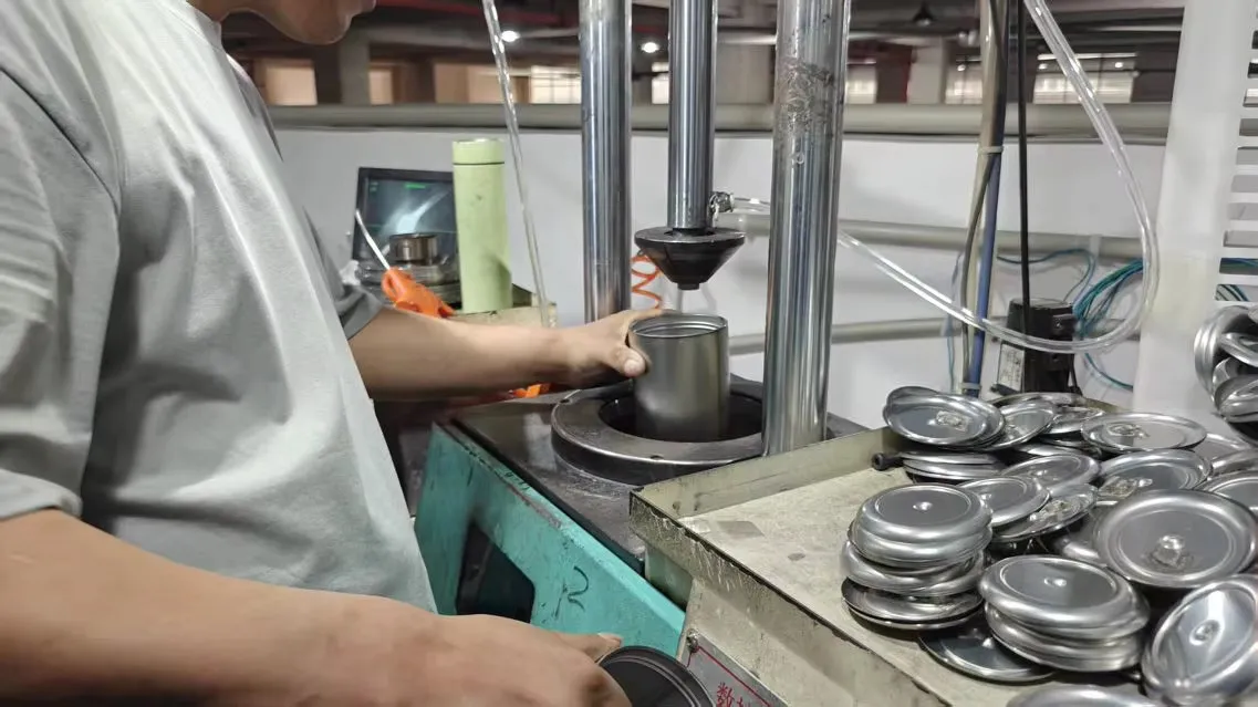 Metal drinkware components arranged beside a processing workstation