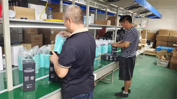 Workers comparing finished colored drinkware beside the assembly line