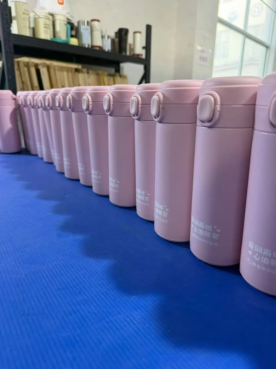 Row of pink coated tumblers prepared for production inspection