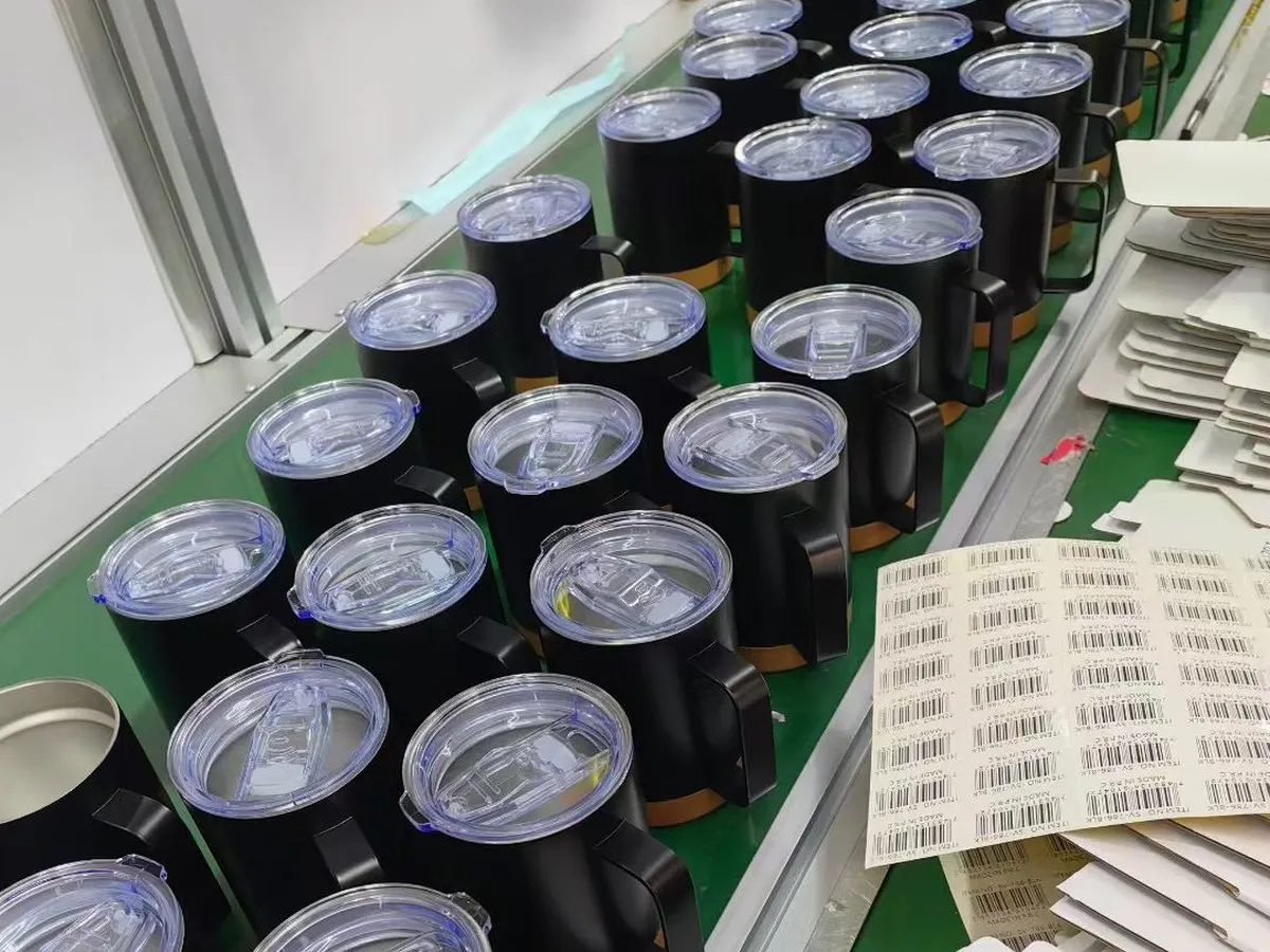 Transparent tumbler lids fitted to handled cups during bulk production