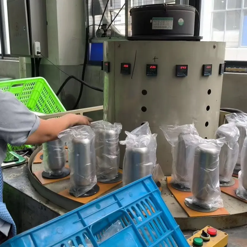 Worker checking stainless steel tumbler bodies at an in-process inspection station