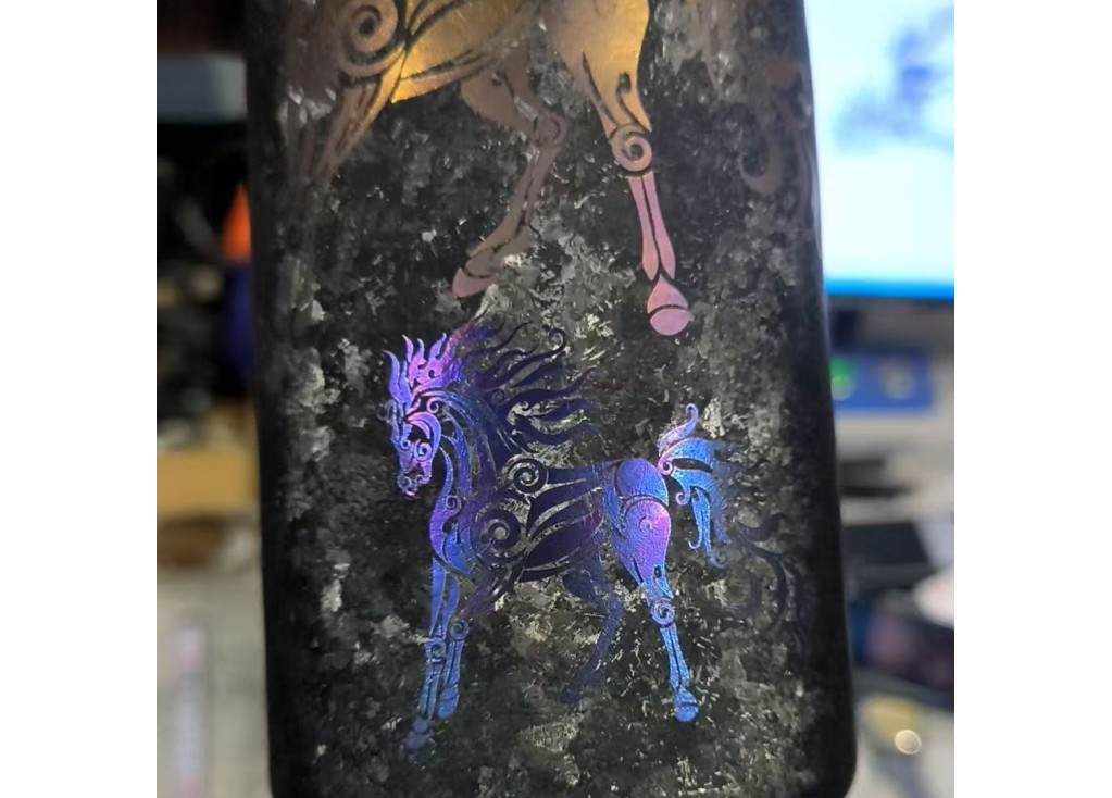 Gold, blue, and purple laser markings on titanium drinkware
