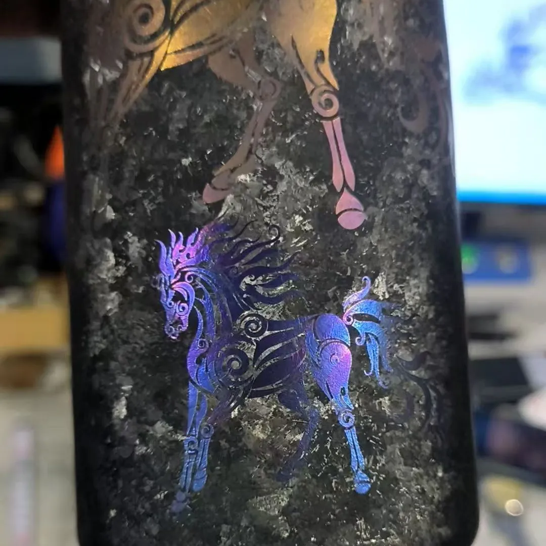 Gold, blue, and purple laser markings on titanium drinkware