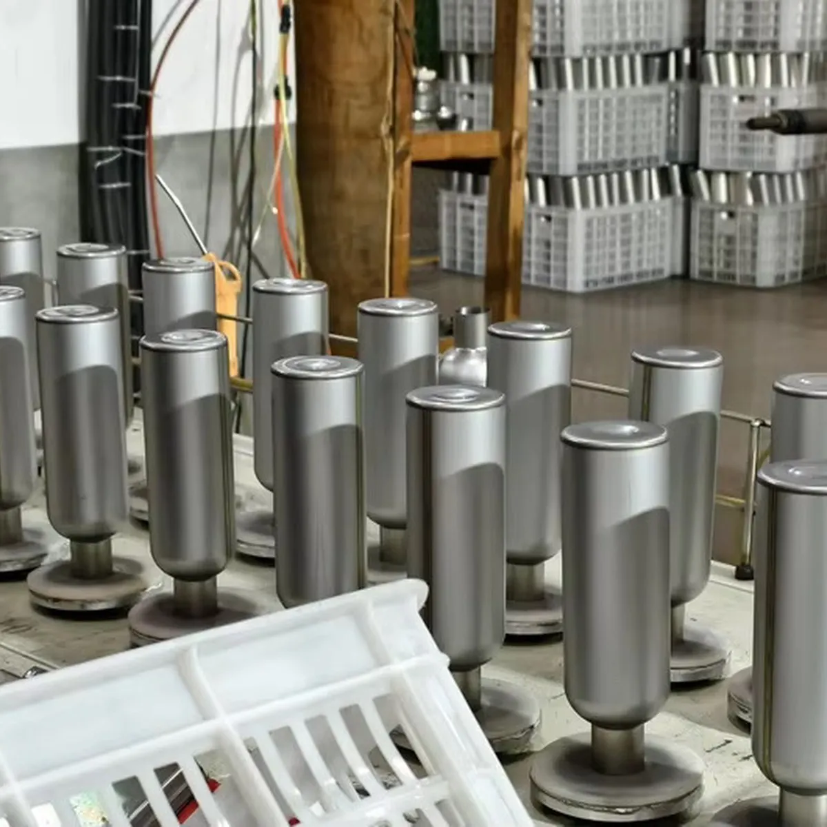 Unfinished stainless steel tumbler bodies arranged at a cup body forming line
