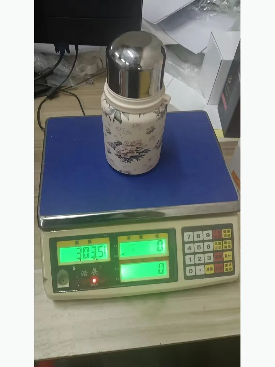 Finished stainless steel drinkware unit weighing 303 grams on a production scale