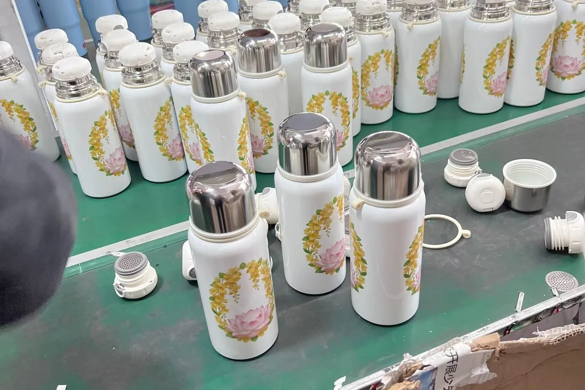 Drinkware components and finished units arranged at an assembly workstation