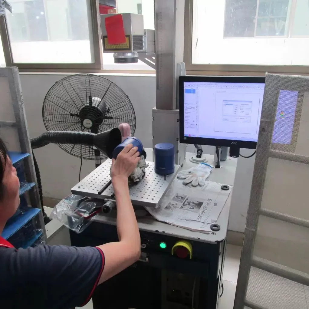 Operator using a measuring system at a tumbler production workstation