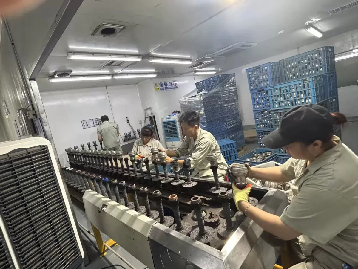 Operators checking black drinkware components along a production line