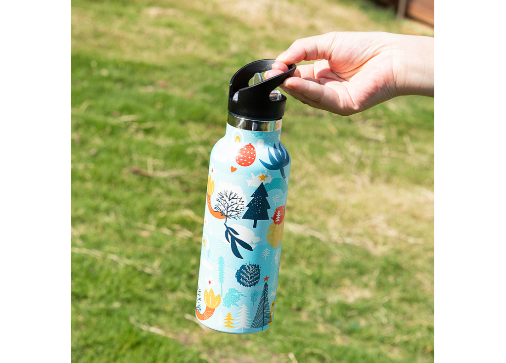Hand holding a colorful patterned water bottle outdoors.