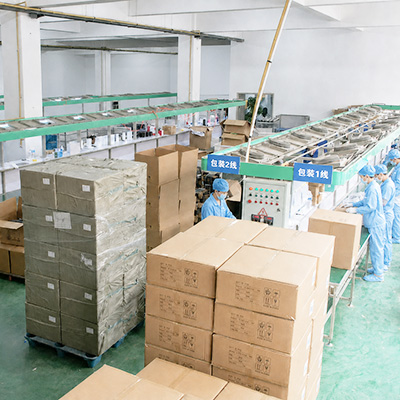 Workers and stacked cartons along drinkware packaging lines